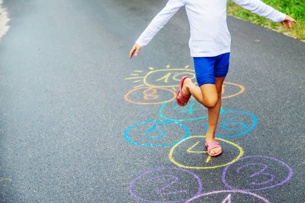 clásicos de salto infantil en el pavimento. enfoque selectivo. - little girls sidewalk child chalk fotografías e imágenes de stock