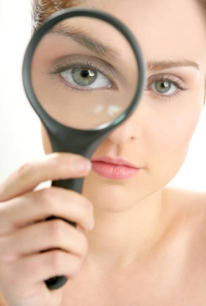 woman with magnifier lens on eye - magnifying glass lens holding europe imagens e fotografias de stock