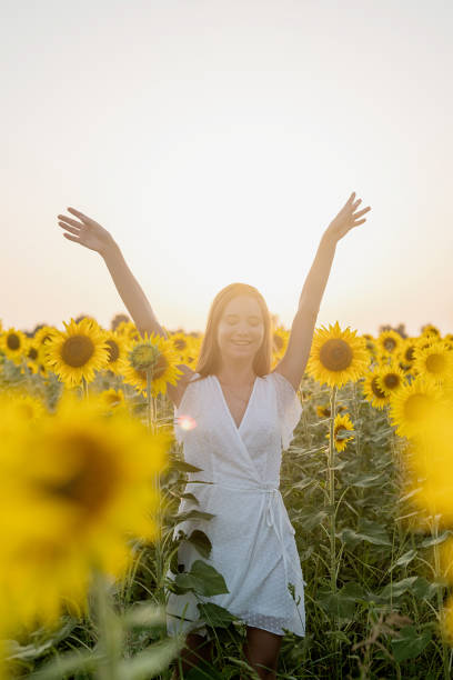 istock young beautiful woman between sunflowers in sunset 1338666549