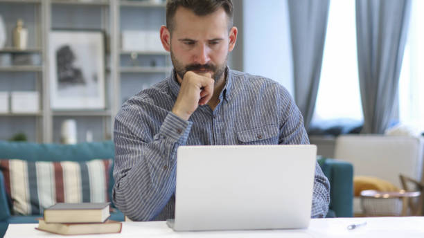 istock Pensive Man Thinking and Working on Laptop 1338668573