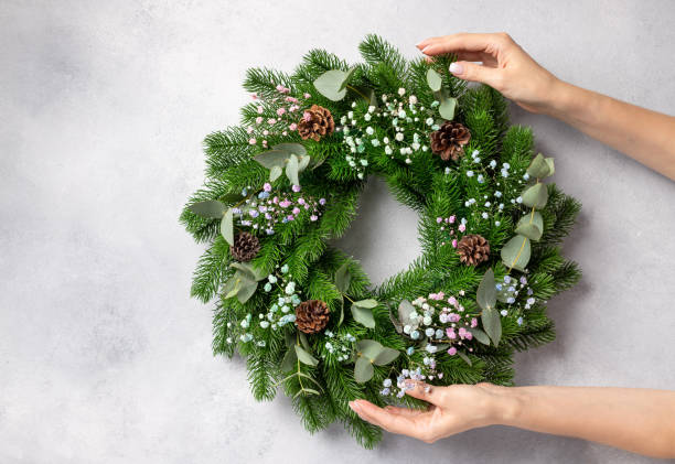 istock florist hands holding Christmas wreath 1338669717