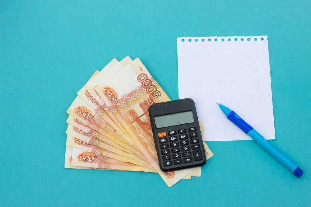 istock business concept. notepad, money and calculator on blue table 1338671293