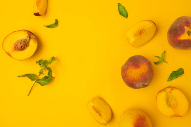 istock Ripe juicy cut peaches on yellow background. Flat lay, top view, copy space. 1338672315