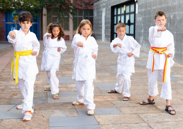 istock Group of schoolchildren practicing karate at schoolyard 1338673744