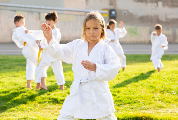 istock Preteen girl practicing karate with group in summer park 1338673770