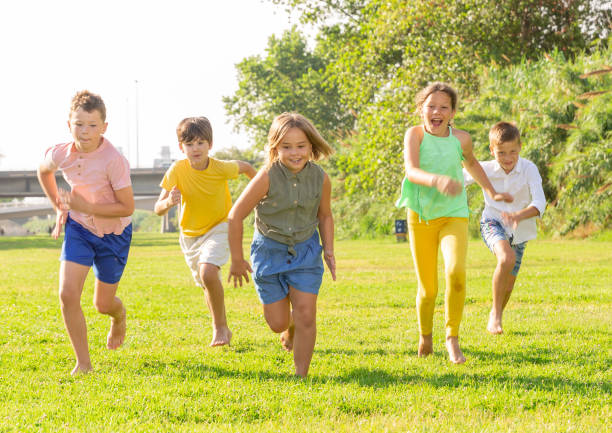 istock Barefoot kids running on green grass 1338673776