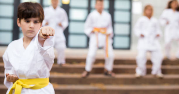 istock Boy in kimono during training karate exercises at summer outdoors 1338673809