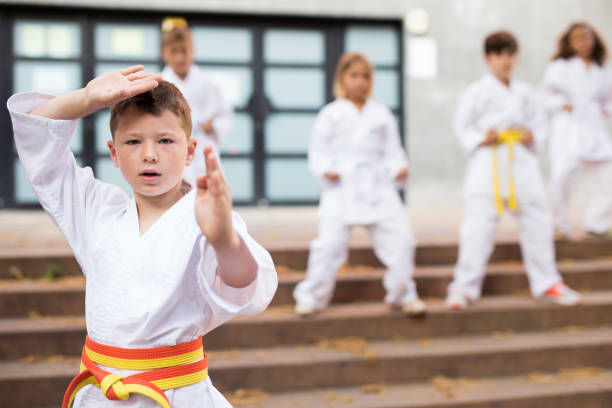 istock Preteen boy practicing karate at schoolyard 1338673816