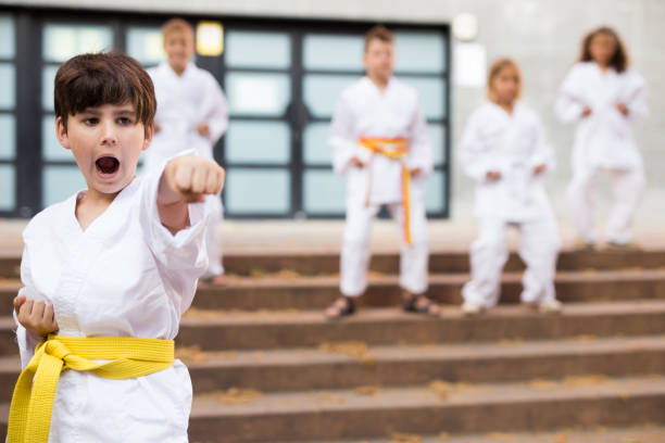istock Boy in kimono doing karate moves in foreground 1338673822