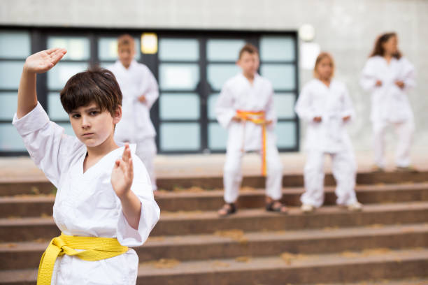 istock Little boy make karate exercises on city street 1338673823