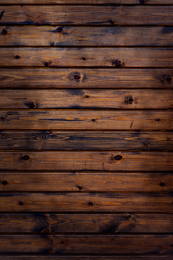 Horizontal old wooden planks of dark brown color damaged