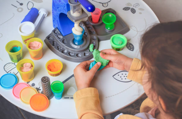 istock Little girl playing with plasticine making shapes 1338681332