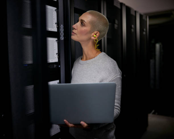 istock Shot of a young female engineer working in a server room 1338682575
