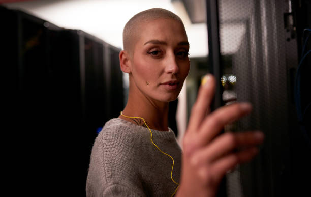 istock Shot of a young female engineer working in a server room 1338682576