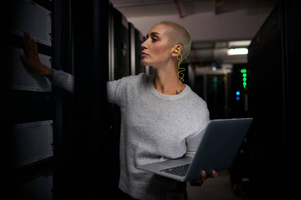 tiro de uma jovem engenheira trabalhando em uma sala de servidores - data center computer programmer women - fotografias e filmes do acervo