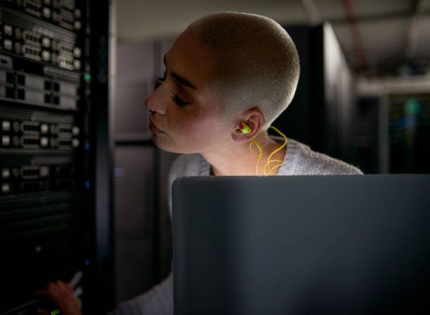 istock Shot of a young female engineer working in a server room 1338682579