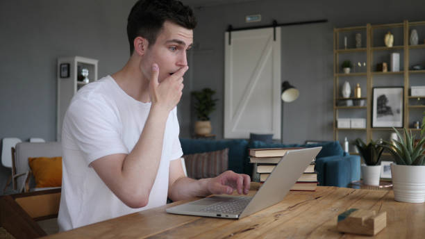 shocked, stunned man wondering and working on laptop - 16318 imagens e fotografias de stock