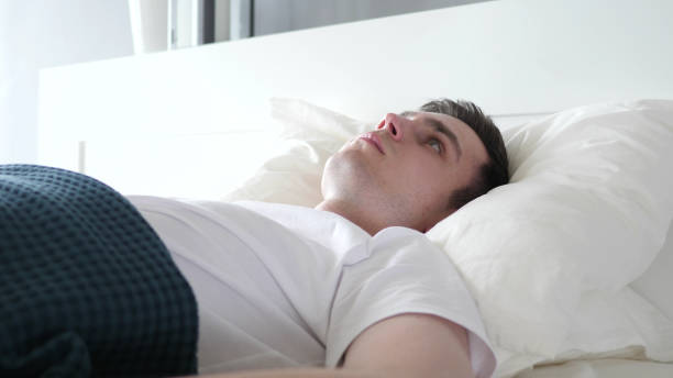 istock Close Up of Man Waking Up From Sleep in Bed 1338683105