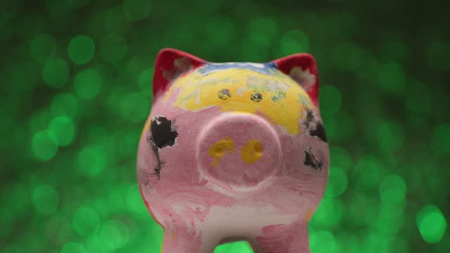 green lights background presenting colorful painted piggy bank in a project video while camera zooming out