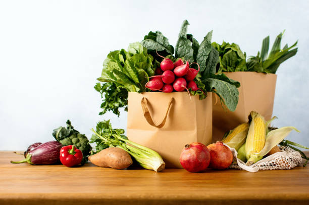 Healthy food shopping or delivery concept Fresh vegetarian food shopping or delivery concept, front view of a variety of fresh produce in a paper or textile shopping bags paper bag stock pictures, royalty-free photos & images