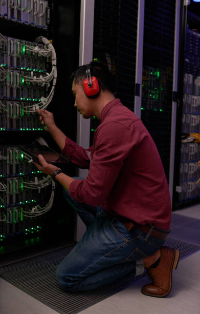 istock Shot of a young male engineer working in a server room 1338686564