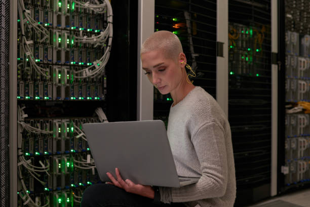 istock Shot of a young female engineer working in a server room 1338686566