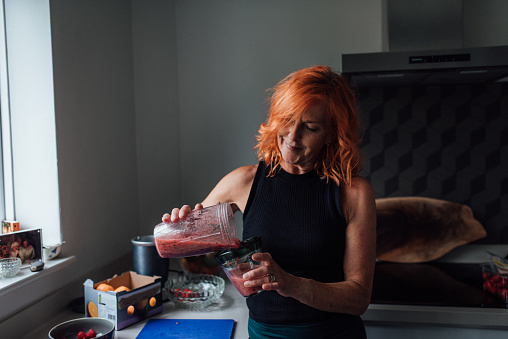 Woman pouring a smoothie into a glass