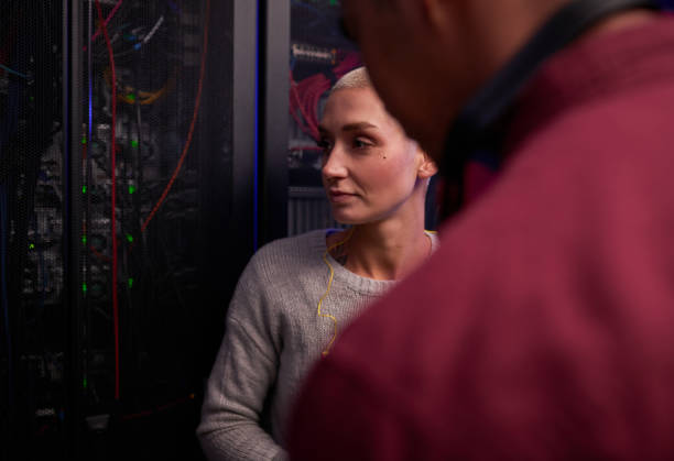 istock Shot of two young engineers working in a server room 1338687191