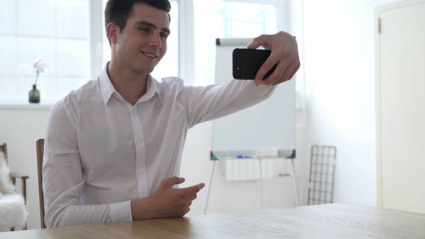 istock Man Taking Selfie with Smartphone in Office 1338687630