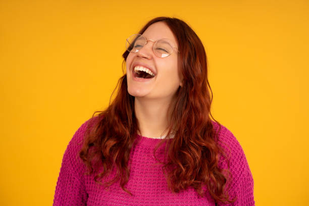 istock Cheerful young woman smiling while standing on an isolated background. 1338688183