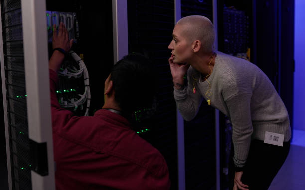 istock Shot of two young engineers working in a server room 1338688346