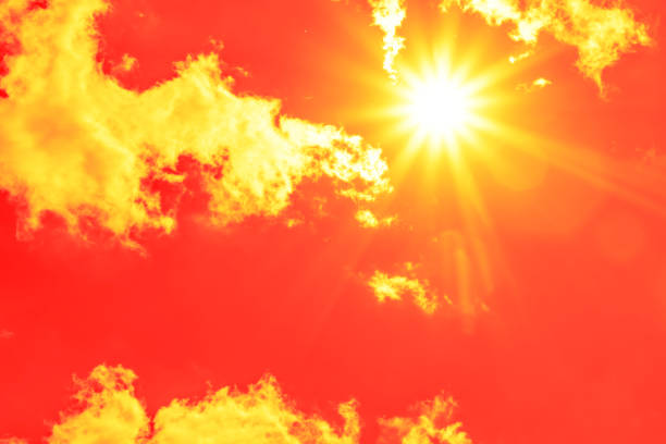 istock Bright sun with beautiful beams in the sky with clouds (toned in red) 1338688463