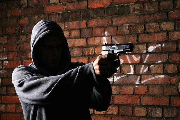 pistolet transporter hoodlum visage - gangster photos et images de collection