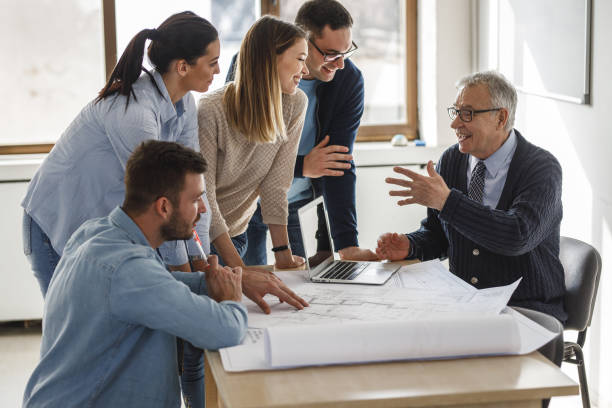 istock College professor examining blueprint with group of his students. 1338691799