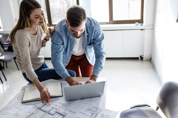 istock Two students of architecture examining blueprint in classroom.Educational concept. 1338691833