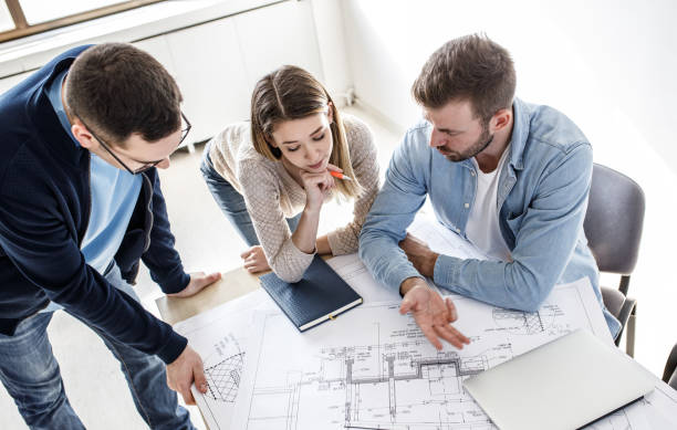 istock Group of architecture students examining blueprint .Educational concept. 1338691834