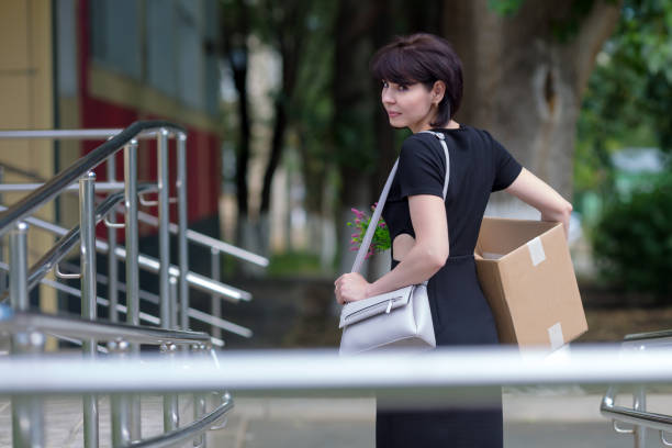 A happy brunette in a black dress with a box of personal belongings is in a hurry for a new job, an employment concept A happy brunette in a black dress with a box of personal belongings is in a hurry for a new job employment concept. slenderman fictional character stock pictures, royalty-free photos & images