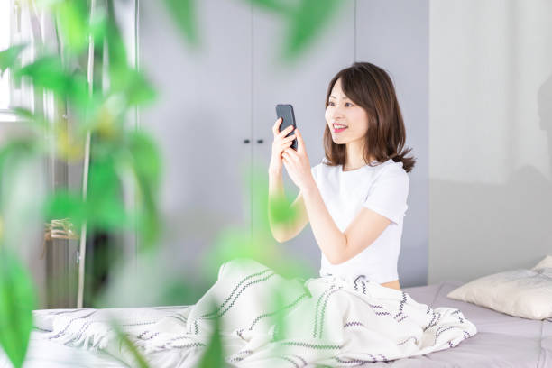 istock Young woman using her phone in bed 1338692147