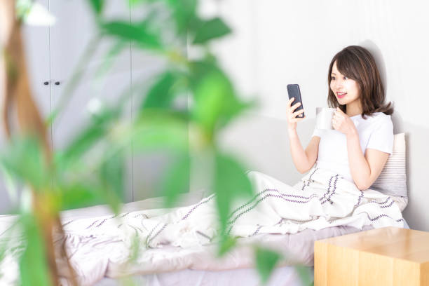 istock Young woman using her phone in bed 1338692157