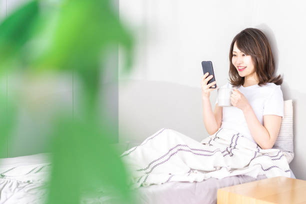 istock Young woman using her phone in bed 1338692159