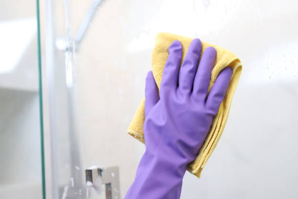 Clean and polish the glass with a rag in the bathroom at home. Cleaning services at home to be hygienic. to prevent bacteria stock photo