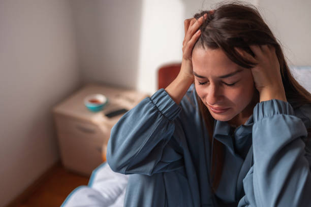istock Woman holding head in hands crying in bed 1338695985