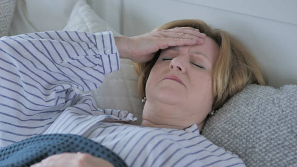 istock Upset Old Woman with Headache Sleeping in Bed 1338696033