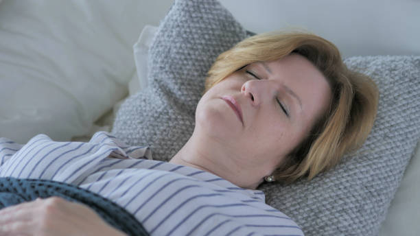 istock Relaxing Old Woman Sleeping in Bed 1338696133