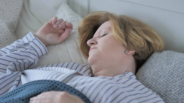 istock Old Woman Sleeping in Bed 1338696158
