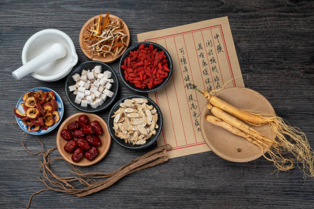 antichi libri di medicina cinese ed erbe sul tavolo - astragalus chinese medicine root plants foto e immagini stock