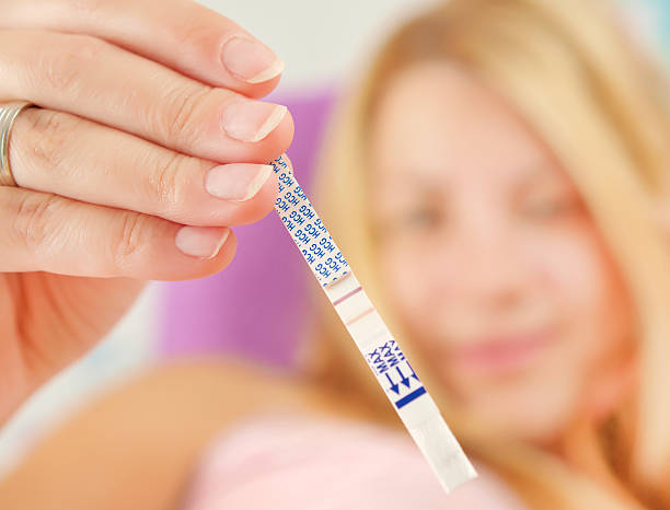 A Women holding positive pregnancy test Positive HCG pregnancy test. Ovulation stock pictures, royalty-free photos & images
