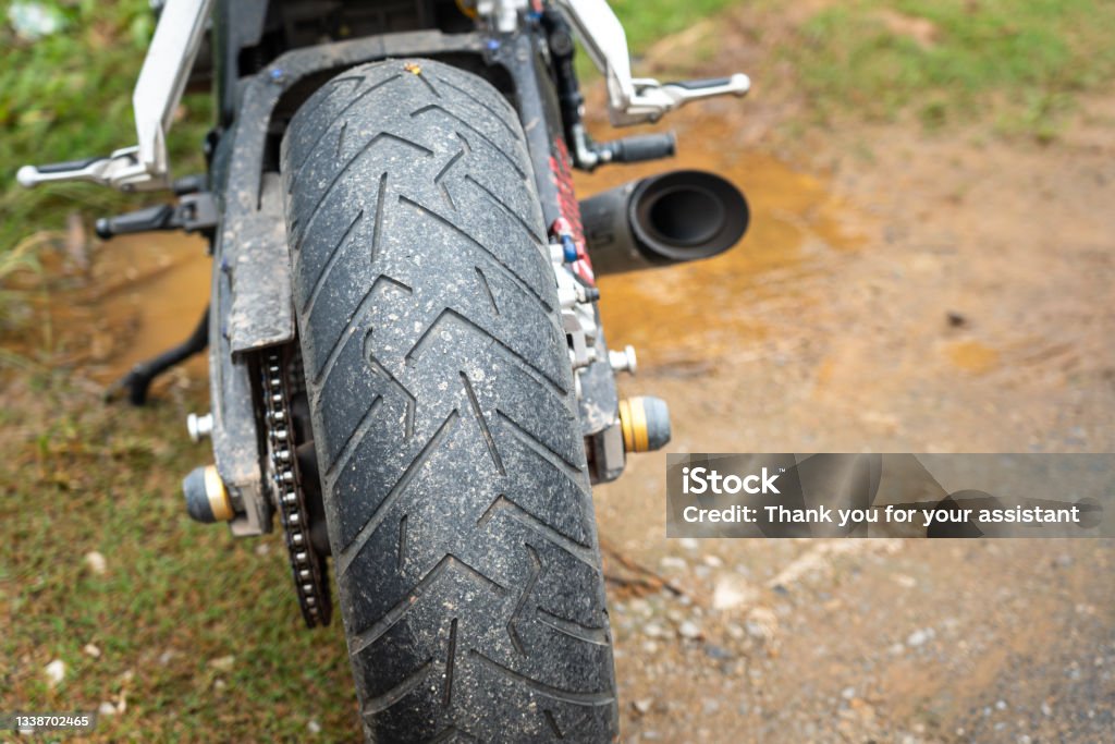 A superbike is parking on the dirt road. A superbike is parking on the dirt road, close-up and selective focus at the big tire. Ready for transportation and travel concept seen. Accidents and Disasters Stock Photo