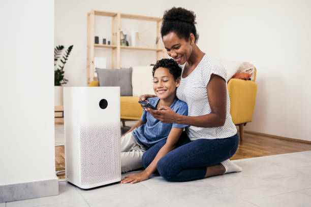 African American woman and her son adjusting air purifier using a smart system