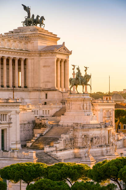 the warm light of the sunset envelops the national monument of the altare della patria in the heart of rome - het forum van rome stockfoto's en -beelden